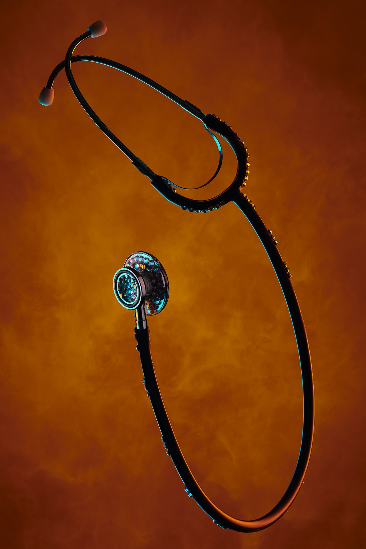 Stethoscope with jewelled features against smoky orange background