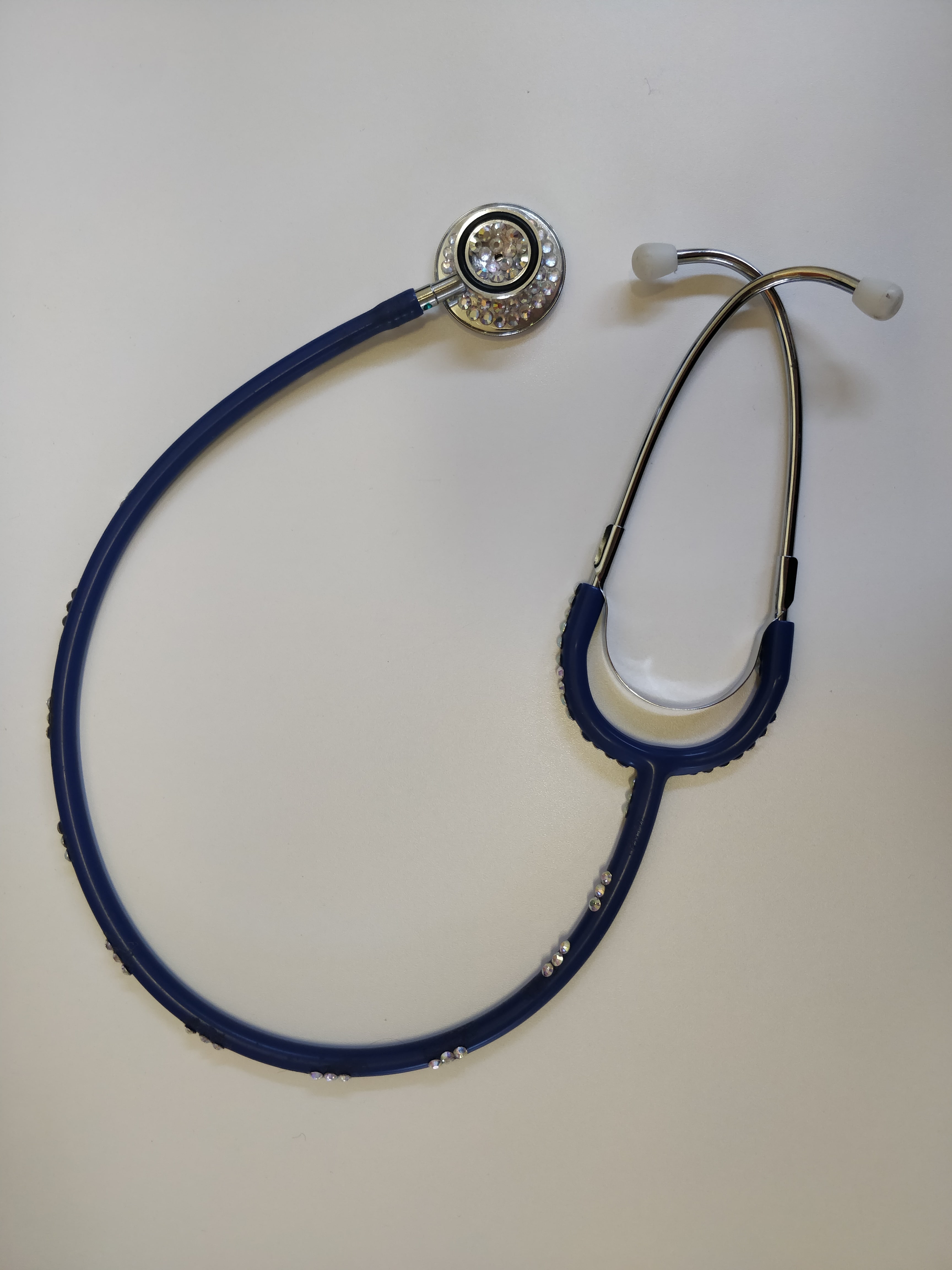 A two eared stethoscope with plastic jewels stuck on the tubing
