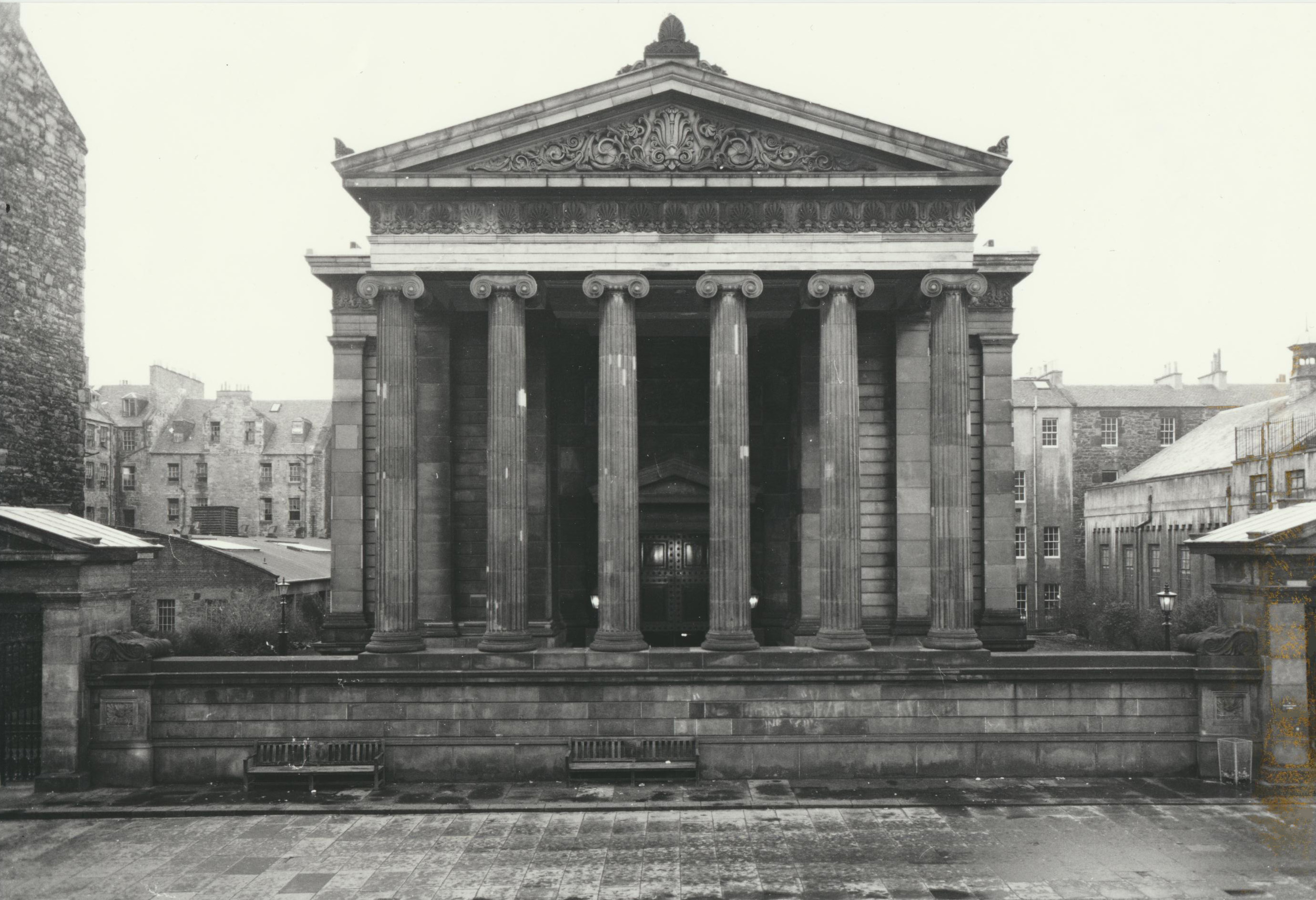 The front of a neoclassical building shaped like a Greek temple.