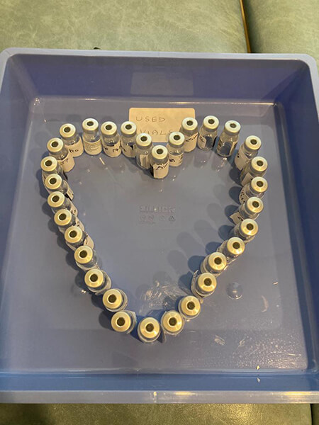 A display of vaccine vials in a heart shape.