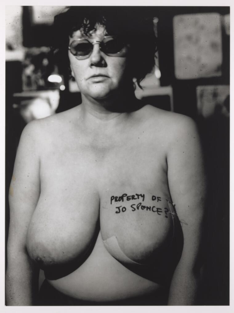 Portrait of Jo Spence with 'Property of Jo Spence?' written in pen on her breast