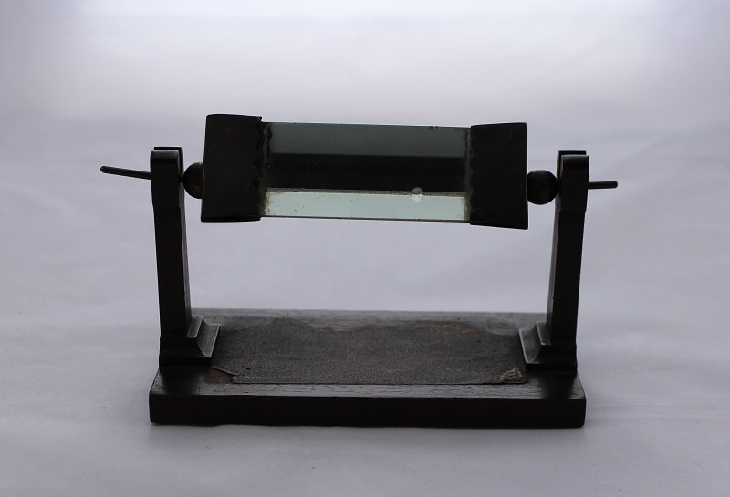 Glass triangular prism with wooden stand.