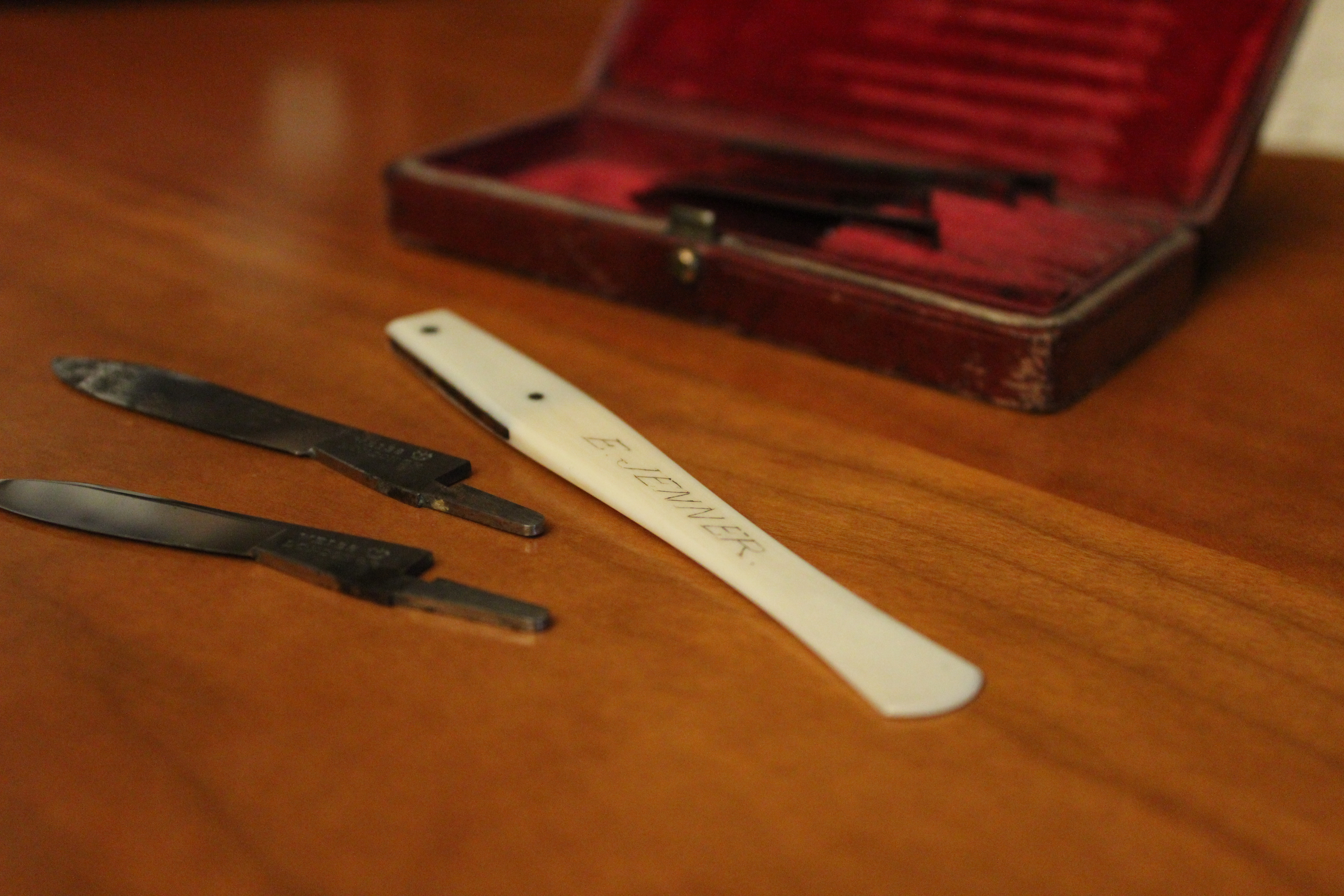An open wooden case displaying a scalpel set with 'Jenner' transcribed.