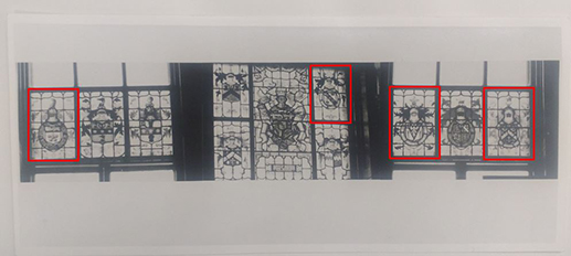Black and white photograph of stained glass panels, with four highlighted in red.