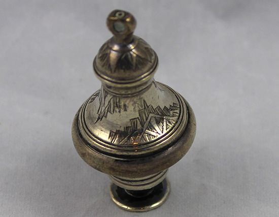 A silver pomander in the shape of a vase.