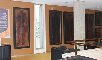 Photograph of six anatomical tables displayed on an internal balcony