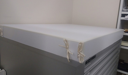 Photograph of a white plastic cover on top of a chest