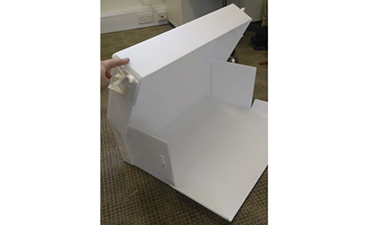 Photograph of a white plastic box, partly folded together