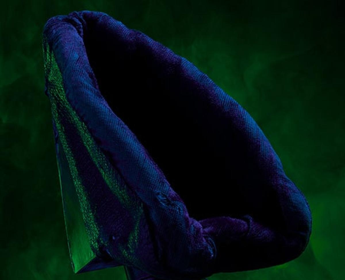 Dark blue oval shaped item on dark green smoky background