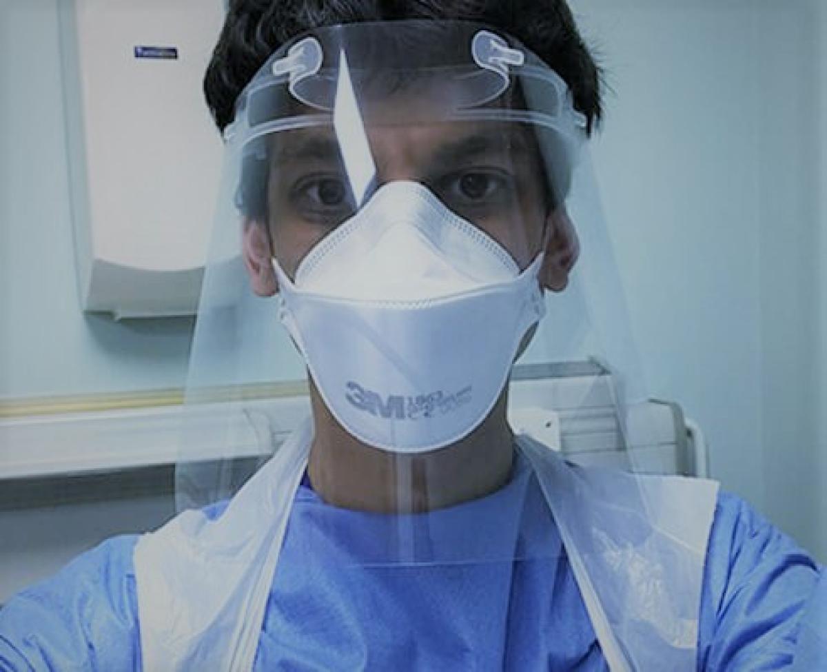 Doctor wearing PPE visor and mask.